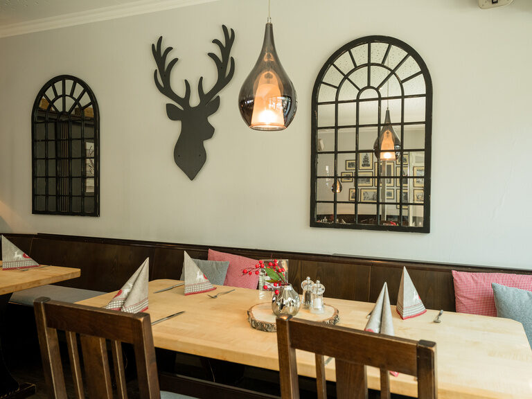 Ein gemütlicher Speisesaal mit Holztischen und Stühlen in Xanten.