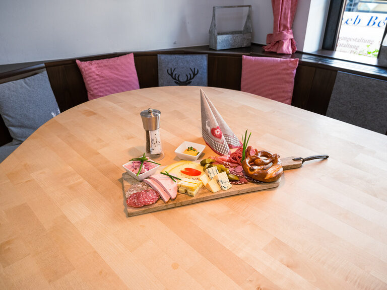 Ein Tablett mit deftigen Speisen auf einem Holztisch im Restaurant.